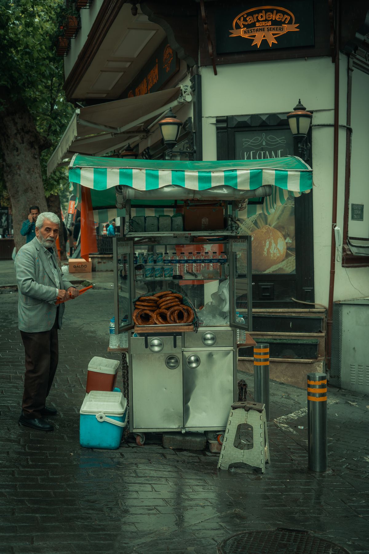 Street food seller in everyday clothing preparing items at his market cart