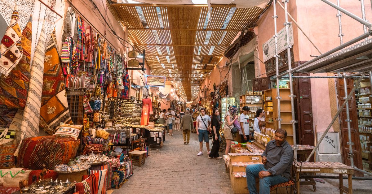 Crowded traditional bazaar with shoppers browsing stalls under arched ceilings